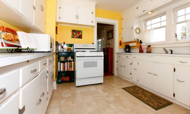 An old stove being carefully removed from a kitchen.